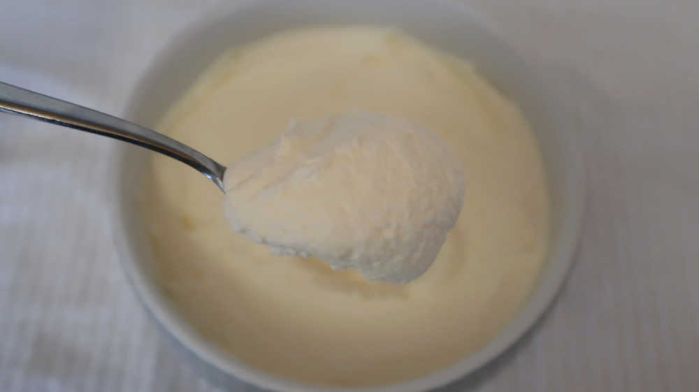 Spoon of homemade lemon mousse dessert with mascarpone cheese